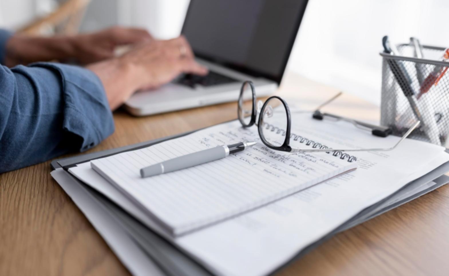 Modern workspace setup with laptop and investment learning materials